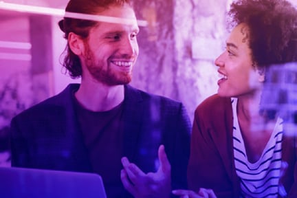 man talking to woman while holding laptop